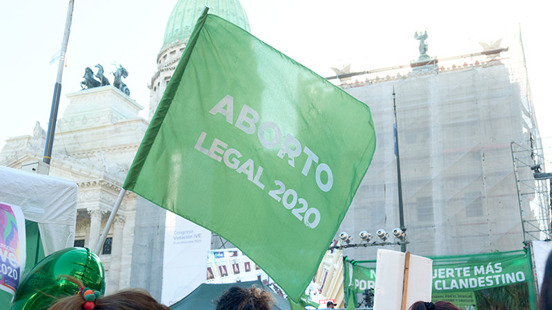 Buenos Aires, Argentina; Dec 10, 2020: Green flag flying at a massive rally in front of the National Congress in support of the legal abortion law. Feminist demonstration during the Covid pandemic