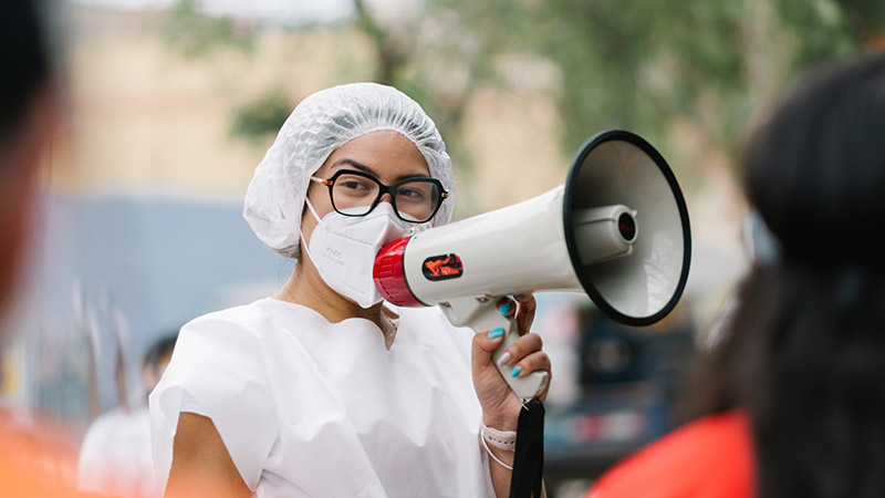 Callao, Lima- PeruÌ�-November, 7, 2020- Nurse with a megaphone informs the neighbors that vaccination against diphtheria is being carried out in the national vaccination campaign in Peru