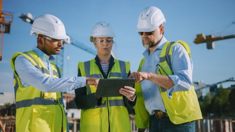 Diverse,Team,Of,Specialists,Use,Tablet,Computer,On,Construction,Site.