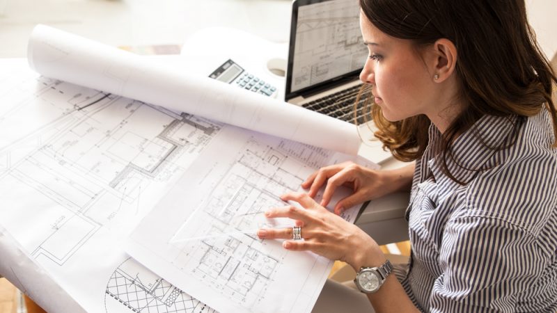 Female,Architect,Working,At,Home.she,Looking,Blueprints.