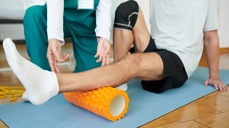 Ejercicio preventivo guiado por terapeuta físico para futbolista con lesión de rodilla
