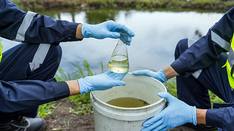 Investigadores ambientales analizando calidad del agua en canal durante el Día Mundial del Medio Ambiente