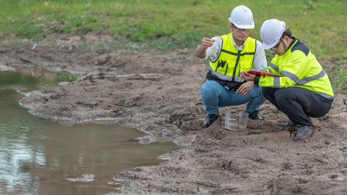 Ingenieros ambientales inspeccionando calidad del agua en laboratorio para proyectos ambientales de protección